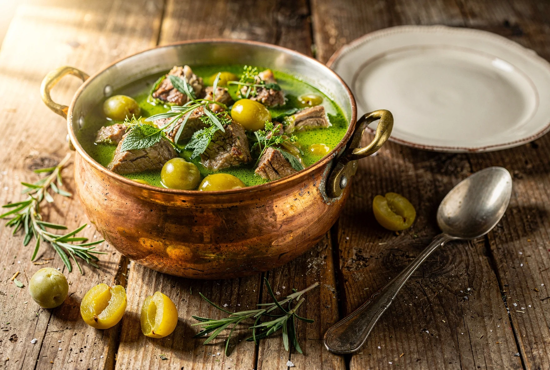 Georgian chakapuli lamb stew with herbs in a copper pot