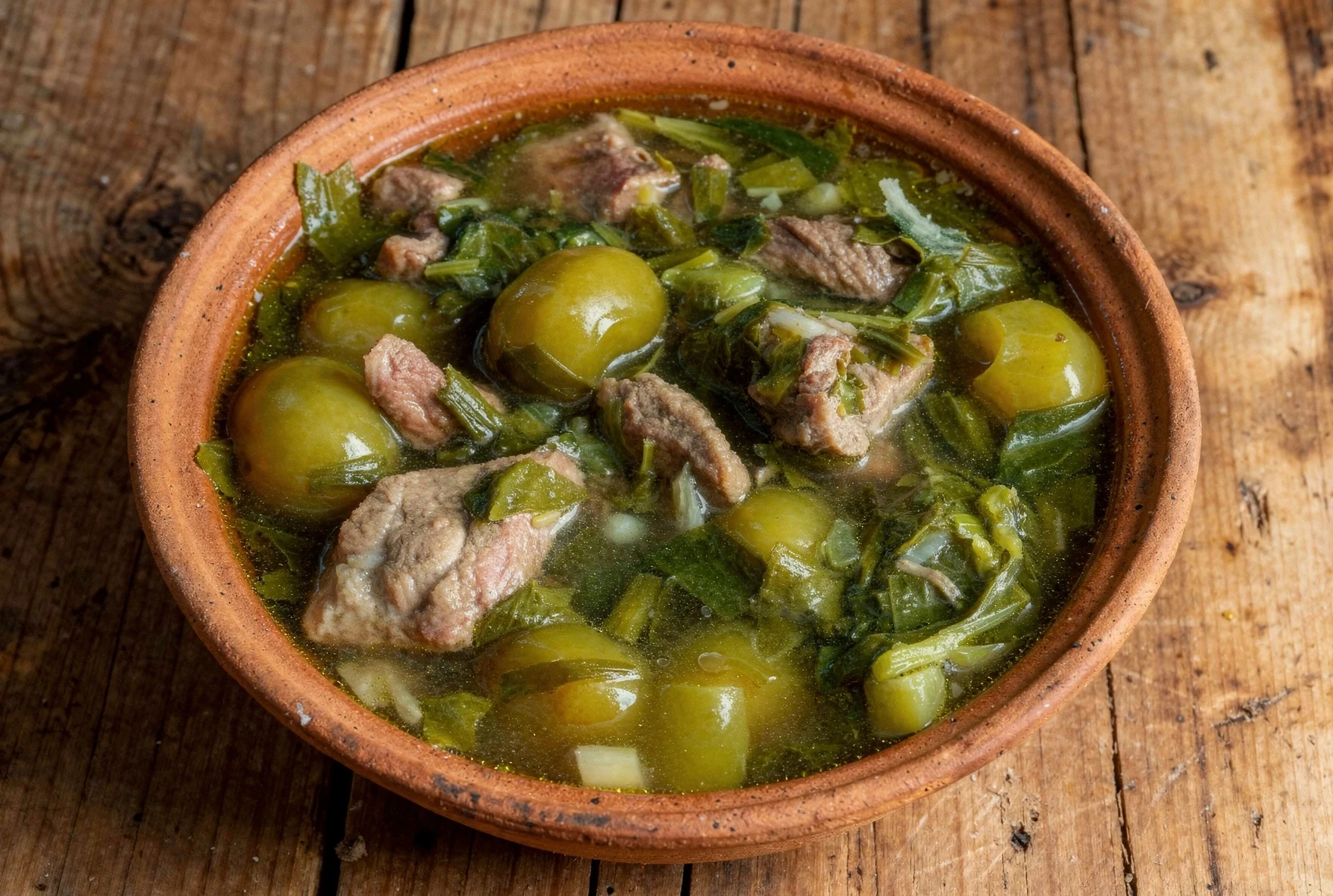 Georgian chakapuli, lamb stew with fresh tarragon and sour plums in a clay pot